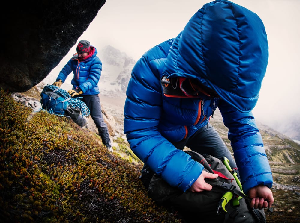 Ally and Calum acking and leaving the shelter of the bivvi cave, Patagonia.